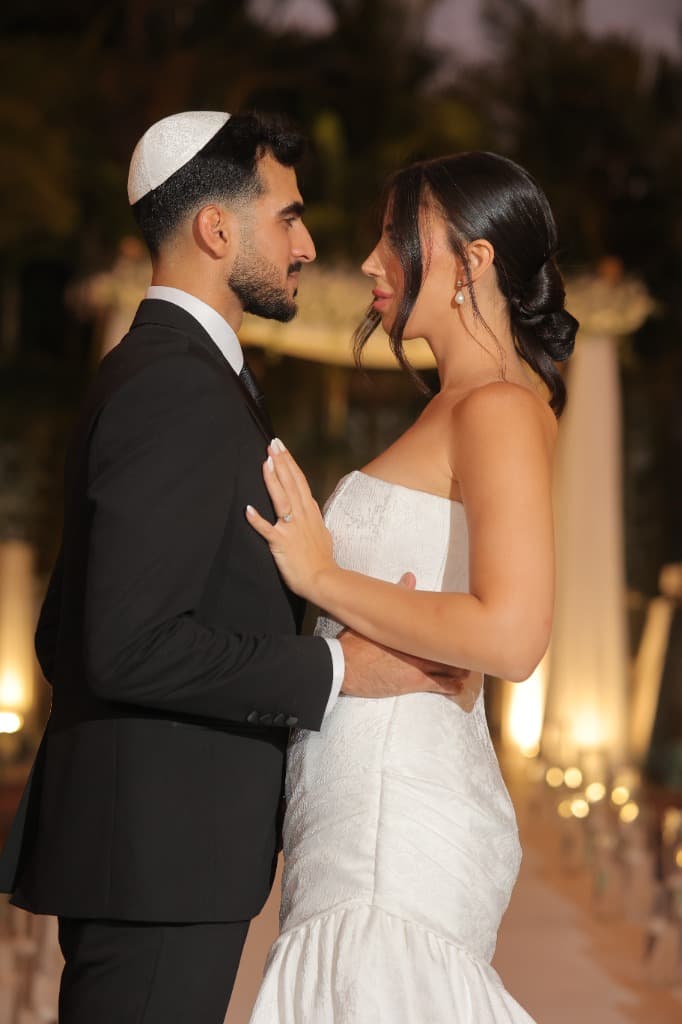 זוג באירוע חתונה — כלה בשמלה לבנה וחתן בחליפה שחורה
